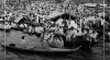 Masyarakat menyaksikan pertandingan balap perahu di Sungai Musi, Palembang, 30 Agustus 1949.