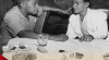 Menteri Penerangan Sudibjo (kiri) dan Wakil Perdana Menteri II Idham Chalid berbincang pada Upacara Serah Terima Jabatan Menteri Penerangan di ruang rapat Kementerian Penerangan RI, 11 April 1957